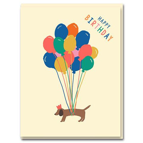 sausage dog is levitated by colourful balloons. 'happy birthday' written on the top corner.  base baby pink