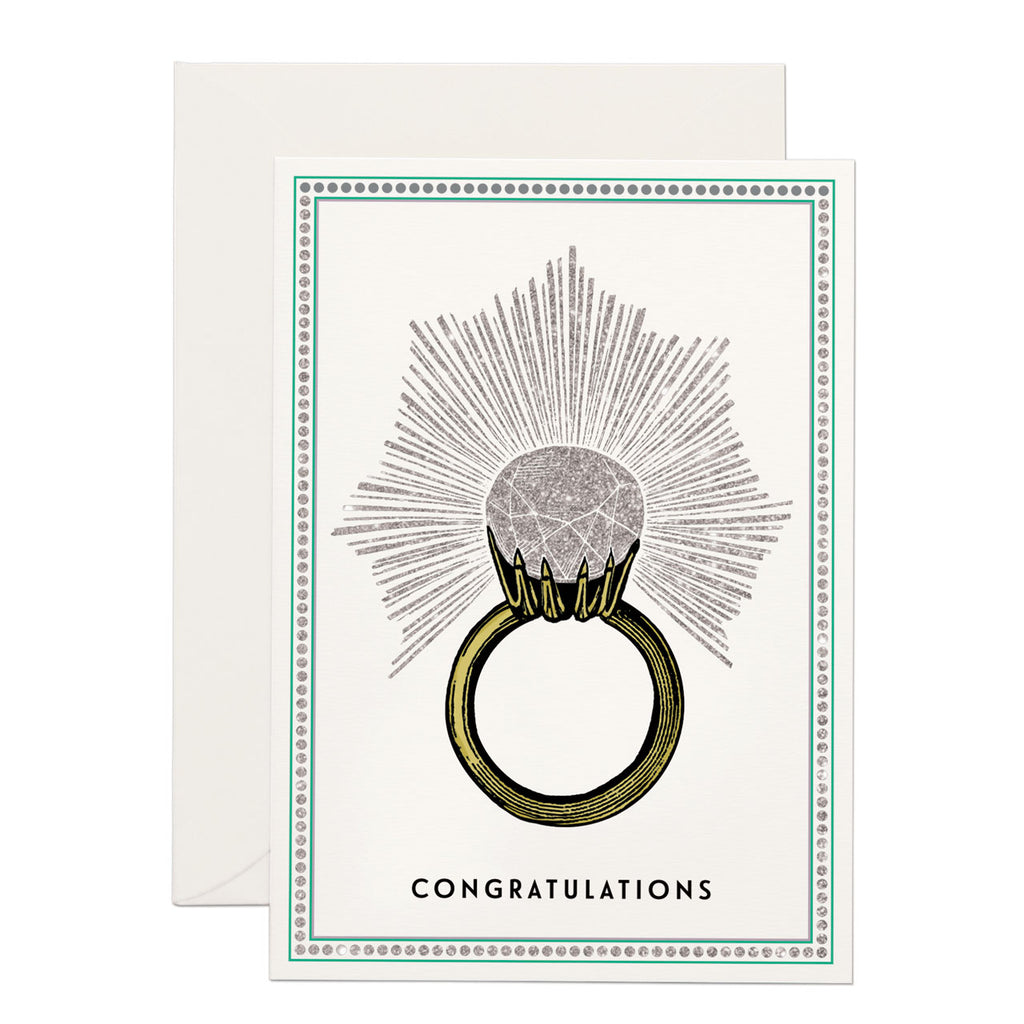 a huge engagement ring , 'congratulations' written at the bottom. base white